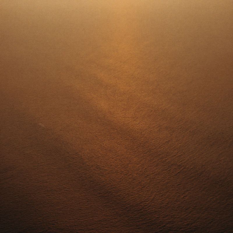 Golden water moving over textured sand